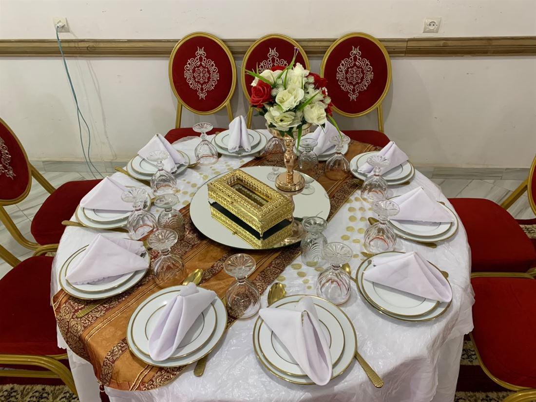 Table dressée avec vaisselle dorée et fleurs pour un événement